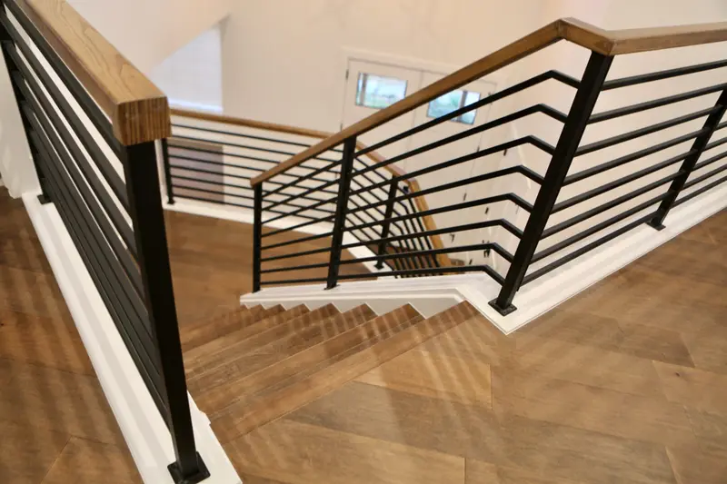 Wood staircase with black horizontal railings in RSRT's complete Boulder home remodel